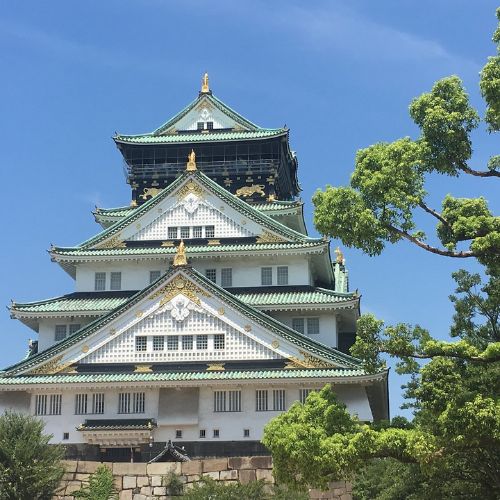 Castelo de Osaka cercado por jardins e cerejeiras